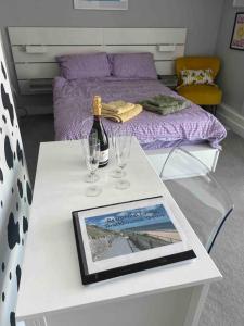 a table with two glasses and a bottle of wine at Stunning Bright Two Bedroom Apartment In Southbourne in Southbourne