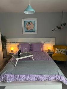 a bedroom with a purple bed with a table and a chair at Stunning Bright Two Bedroom Apartment In Southbourne in Southbourne