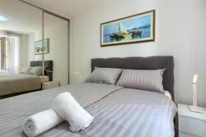 een slaapkamer met een groot bed en een witte stoel bij Apartment Tale - Brand new apartment in Pula's old town, with free Netflix and Wi-Fi in Pula