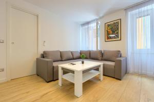 Apartment Tale - Brand new apartment in Pula's old town, with free Netflix and Wi-Fi في بولا: غرفة معيشة مع أريكة وطاولة