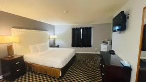 um quarto de hotel com uma cama e uma televisão em Falls Lodge by the Falls (Formerly Knights Inn) em Cataratas do Niágara