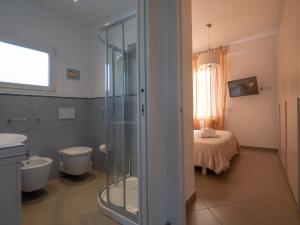 a bathroom with a shower and a toilet and a bed at Appartamento Lavanda "A Casa Felice" in Pietra Ligure +16 photos