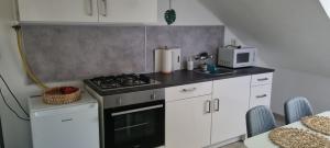 a kitchen with a stove and a microwave at Kiara Apartman in Siófok