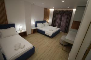 a hotel room with two beds and a couch at Julia Hotel in Sarandë