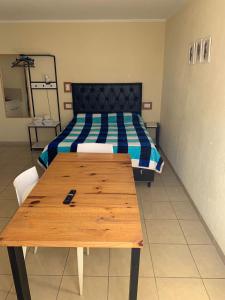 a bedroom with a wooden table and a bed at APART PIEDRAS,Cochera,Desayuno seco 3 5 3 5 6 3 4 5 1 4 in Villa María