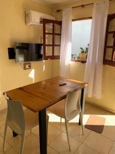 a dining room table with two chairs and a television at APART PIEDRAS,Cochera,Desayuno seco 3 5 3 5 6 3 4 5 1 4 in Villa María