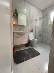 Baño blanco con lavabo y aseo en The VIP Guest - Luxury Home in Nisantasi, en Estambul