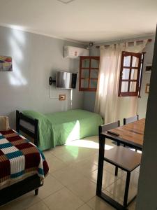 a bedroom with a bed and a table and a tableablish at APART PIEDRAS,Cochera,Desayuno seco 3 5 3 5 6 3 4 5 1 4 in Villa María