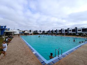 a large swimming pool with many people in it at Ilyass Garden Beach Sidi Rahal in Dar Hamida