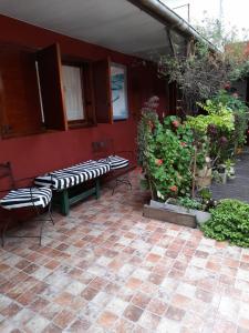 a patio with two benches on a red wall at PH Solís in Mar del Plata