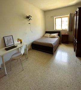 - une chambre avec un lit, un bureau et une fenêtre dans l'établissement St Julian Rainbow, à San Ġiljan