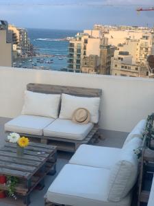 d'un balcon avec vue doté d'un canapé et d'une table. dans l'établissement St Julian Rainbow, à San Ġiljan