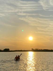 duas pessoas num barco na água ao pôr do sol em Brisas del rio em Formosa