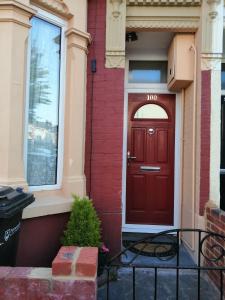 a red door of a house with a sign on it at Angelica place in Portsmouth