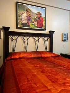 a bedroom with a large painting on the wall at THIZMA HOTELES Ex HotelSantaMaria in Ayacucho