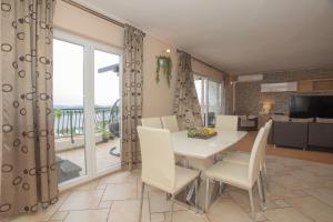 a dining room with a table and chairs and a balcony at Apartment Mozart in Šibenik