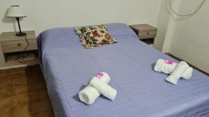 a purple bed with towels on top of it at Italia apart departamentos por día con cochera opcional in Corrientes