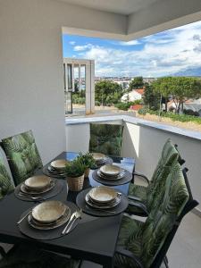Luxury apartment Golden Mint في نوفاليا: طاولة طعام مع صحون وأواني على شرفة