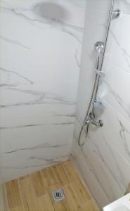 a bathroom with a shower with white marble walls at Studio apartman Endy in Ploče +32 photos