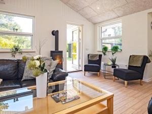 a living room with a couch and a fireplace at 6 person holiday home in Bl vand in Ho