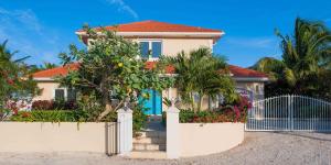 a house with a fence in front of it at In Harmony by Grand Cayman Villas & Condos in Bodden Town