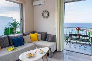 sala de estar con sofá y vistas al océano en Akontio Apartment with Sea View en Panormos Rethymno