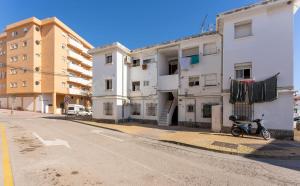 ein Motorrad, das auf einer Straße neben Gebäuden geparkt ist in der Unterkunft Apartamento de un dormitorio cerca de la playa in Estepona