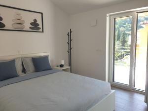 biała sypialnia z dużym łóżkiem i oknem w obiekcie Seafront Apartment Strunjan w mieście Strunjan
