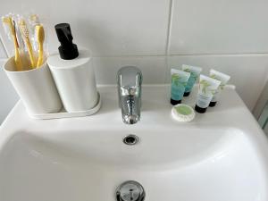 a bathroom sink with toothbrushes and toothpaste at Flat 12 Palm Court in Bournemouth +31 photos
