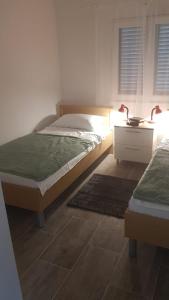a bedroom with two beds and a table with lamps at In the nature by Marko in Benkovac