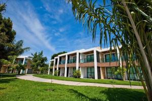 una vista exterior de un edificio con palmeras en Aprto luxo ILOA barra de São Miguel com enxoval, en Barra de São Miguel
