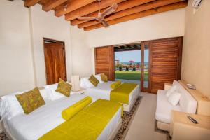 a bedroom with two beds and a couch at Casa Don Luis Lujosa casa frente a la playa 