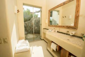 a bathroom with a sink and a mirror and a shower at Casa Don Luis Lujosa casa frente a la playa 