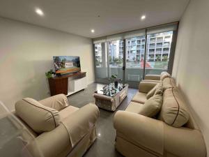 a large living room with couches and a television at Nice Olympic park next to stadium 2b2b1p1study in Sydney