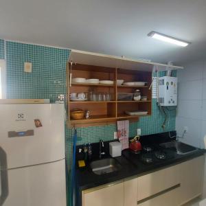 a small kitchen with a sink and a refrigerator at Muro alto condomínio clube in Ipojuca