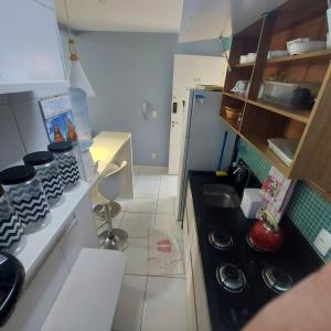 a small kitchen with a stove and a sink at Muro alto condomínio clube in Ipojuca