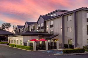 un hotel con ombrelloni rossi in un parcheggio di Best Western Plus Spokane North a Spokane
