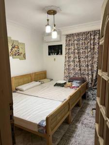 een slaapkamer met 2 bedden in een kamer bij Spacious flat 7 mins to Airport in Caïro