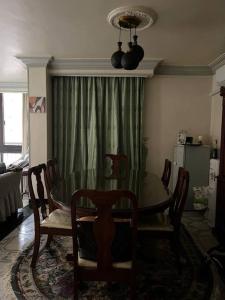 uma sala de jantar com uma mesa de vidro e cadeiras em Spacious flat 7 mins to Airport em Cairo