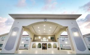 a large white building with a large entry way at SureStay Studio by Best Western Conroe Downtown in Conroe