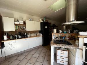a kitchen with white cabinets and a counter top at Cozy Room in the heart of Rødby! 5km from Femern & Puttgarden! in Rødby