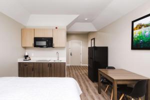 Zimmer mit einem Bett, einem Schreibtisch und einer Küche in der Unterkunft SureStay Studio by Best Western Conroe Downtown in Conroe