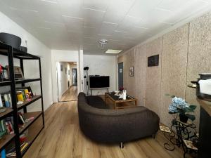 a living room with a couch and a television at Cozy Room in the heart of Rødby! 5km from Femern & Puttgarden! in Rødby