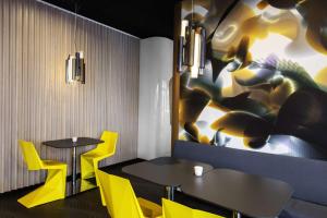 a restaurant with two tables and yellow chairs at prizeotel Erfurt-City in Erfurt