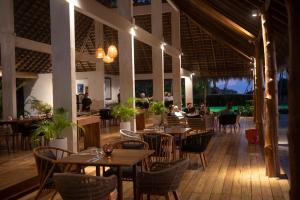 een restaurant met tafels en stoelen en mensen die er zitten bij 81 Palms Resort in Nembrala