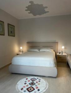a bedroom with a white bed and a white rug at Aquamarine Dreams Apartments in Beach of Durres 150 m from Sea in Durrës