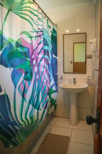 un bagno con un water, un lavandino e uno specchio di Cabañas MANA NUI INN a Hanga Roa Altre 37 foto