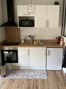 a kitchen with white cabinets and a sink at Mistral gagnant - parking privé in Cassis