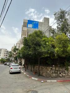 une voiture garée dans une rue en face d'un bâtiment dans l'établissement سفر, à Ramallah