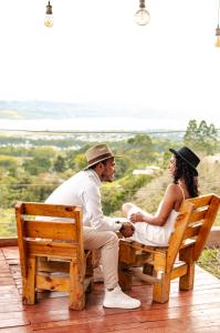 un hombre y una mujer sentados en un banco en Ecolife Calima, en Calima